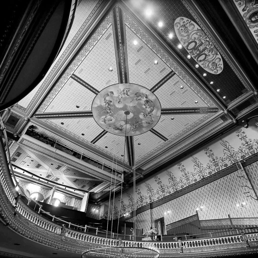 Black and white photo of the ornate ceiling at The Grand Opera House in Oshkosh, which utilized our historic preservation and special services.